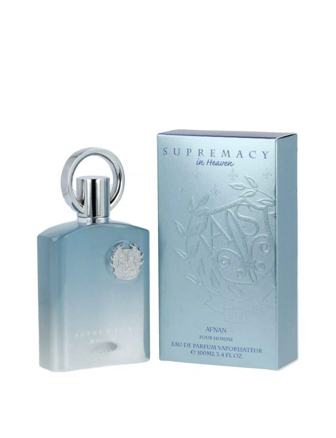 A photograph of a light blue bottle of "Supremacy in Heaven EDP Perfume for Men 3.4 oz/100 ml" by Afnan, placed next to its matching box. The bottle is adorned with a silver cap featuring a circular design, while the box showcases a harmonious color scheme and design elements, creating a tranquil atmosphere.